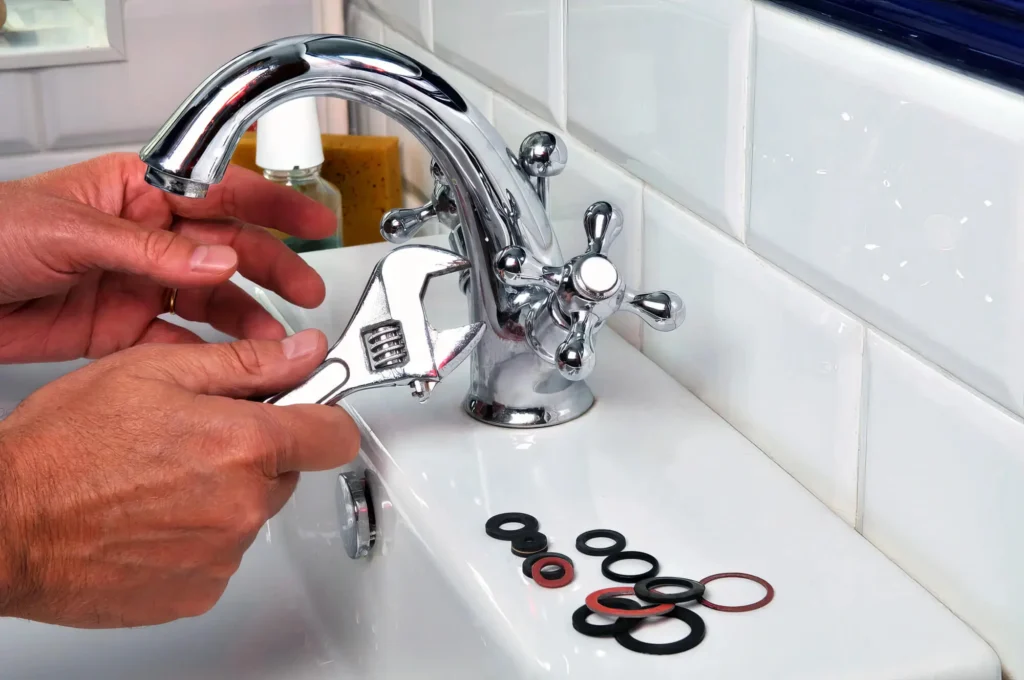 Plumber performing maintenance on a bathroom faucet in La Quinta