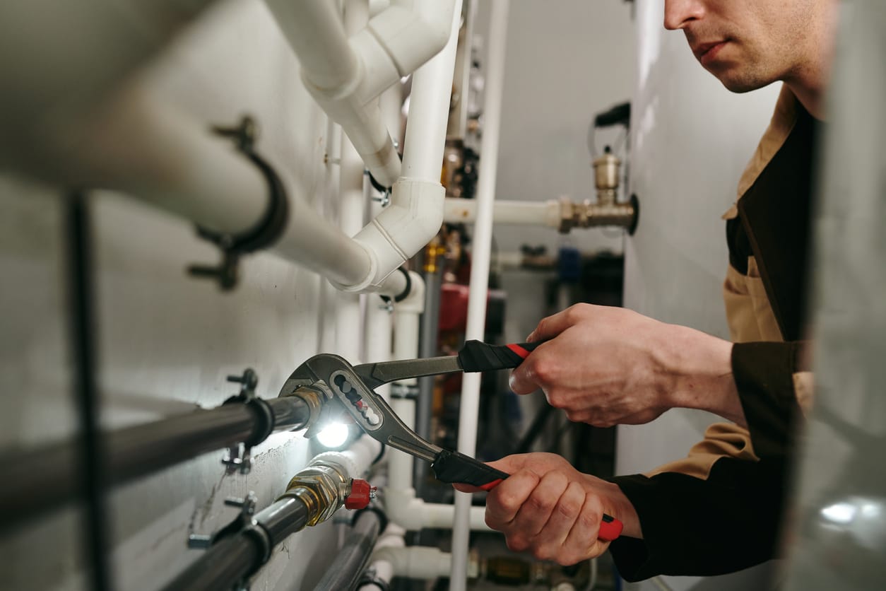 Plumbers maintaining commercial plumbing pipes in La Quinta