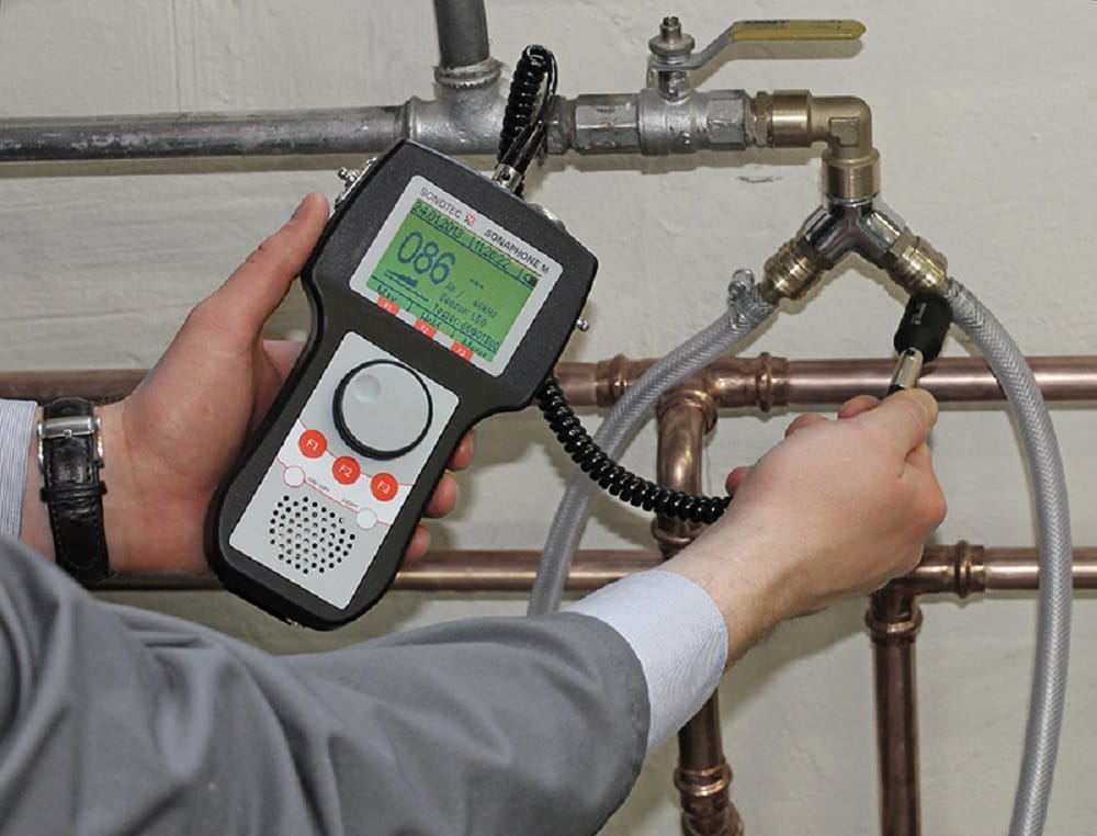 Plumber testing pipes with electronic leak detection equipment in La Quinta
