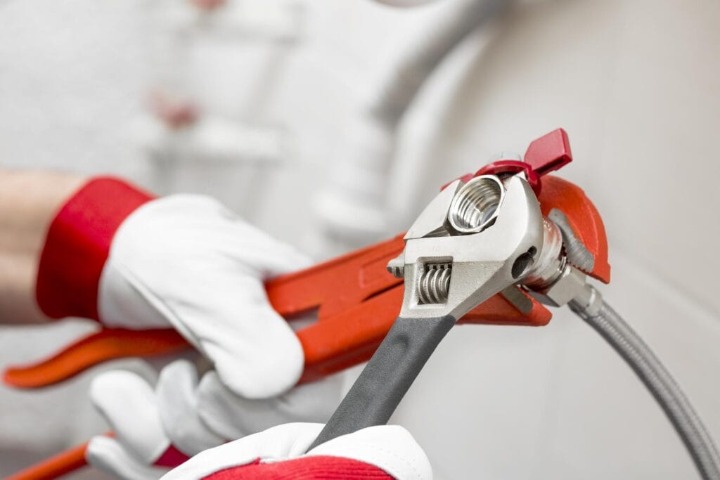 Plumber holding pipe wrenches for an emergency repair in La Quinta