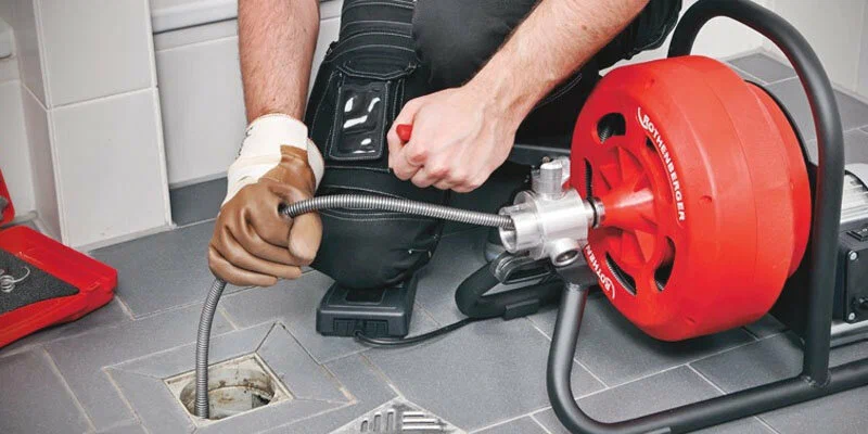Plumber using a drain-cleaning machine in La Quinta