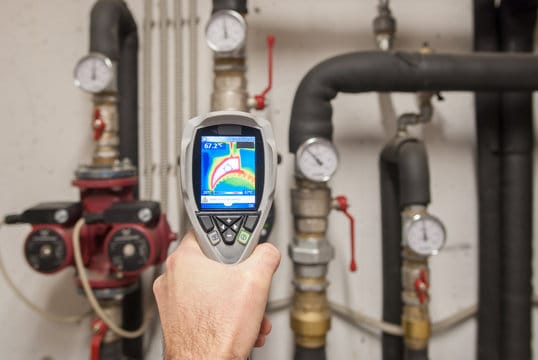Plumber using a thermal imaging camera to inspect pipes in La Quinta