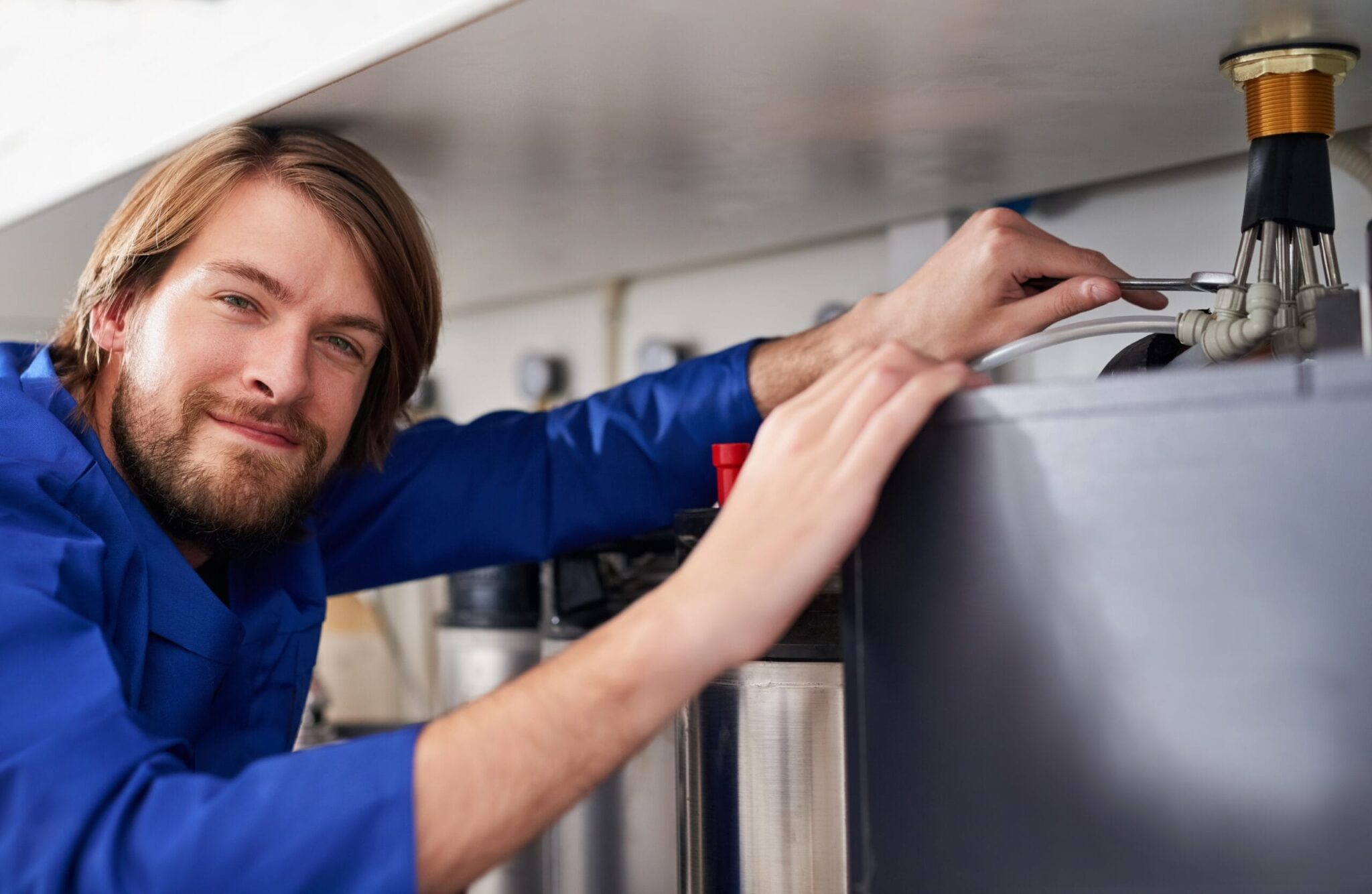 Technician servicing a residential water heater tank in La Quinta