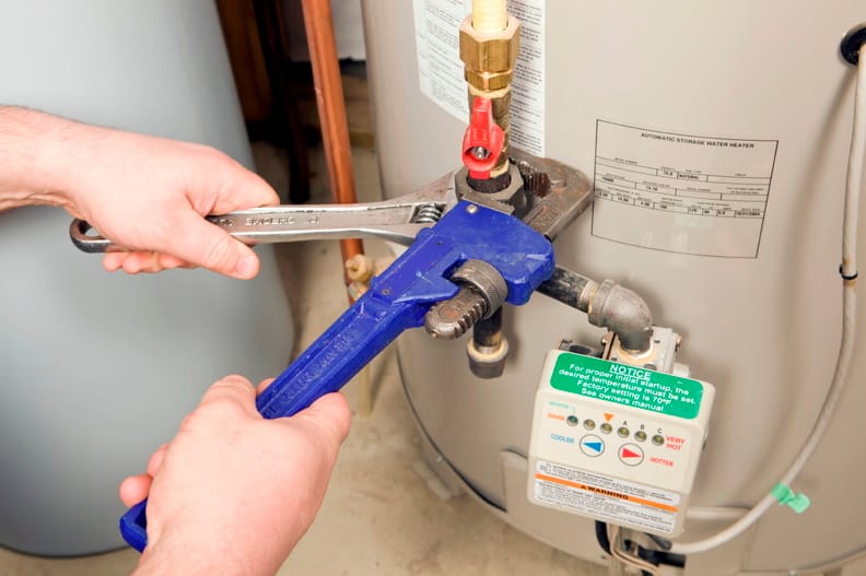 Plumber repairing a water heater valve in La Quinta